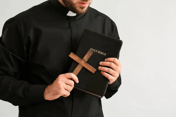 Junger Priester Mit Bibel Auf Hellem Hintergrund — Stockfoto