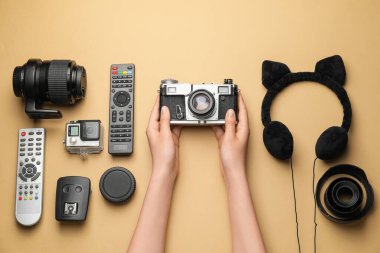 Renkli arka planda farklı modern aygıtlara sahip kadın elleri