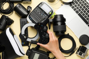 Renkli arka planda farklı modern aygıtlara sahip kadın el