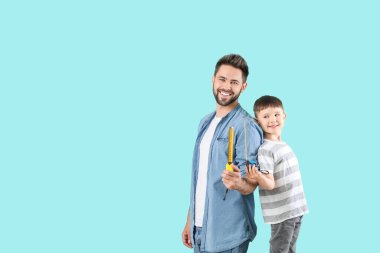 Baba ve oğul renk arkaplanında mezuraları var.