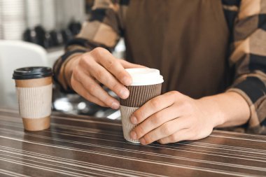Kafede kahveli genç bir barista, yakın plan.