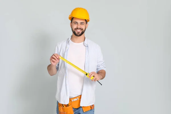 Young Man Measuring Tape Light Background — Stock Photo, Image