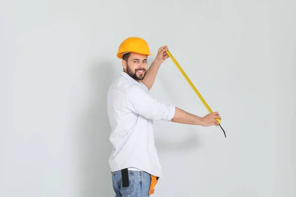 Young Man Measuring Tape Light Background — Stock Photo, Image