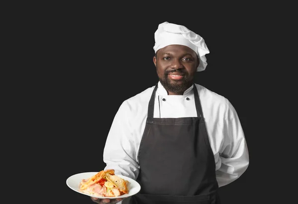 Chef Afroamericano Masculino Con Sabroso Plato Sobre Fondo Oscuro —  Fotos de Stock