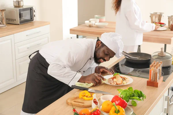 African-American chefs cooking in kitchen