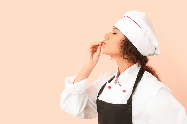 Female African-American chef on color background