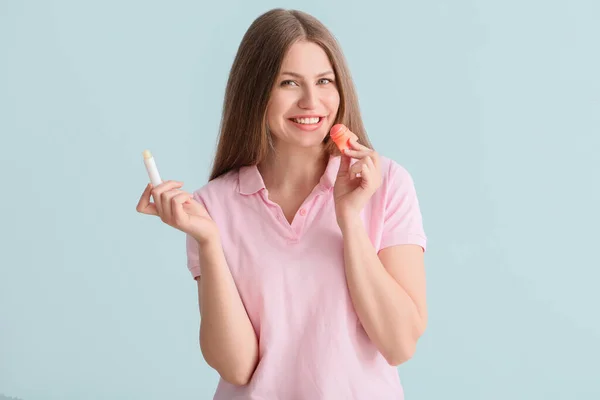 Beautiful Young Woman Lip Balms Light Background — Stock Photo, Image