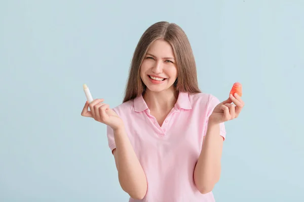 Beautiful Young Woman Lip Balms Light Background — Stock Photo, Image