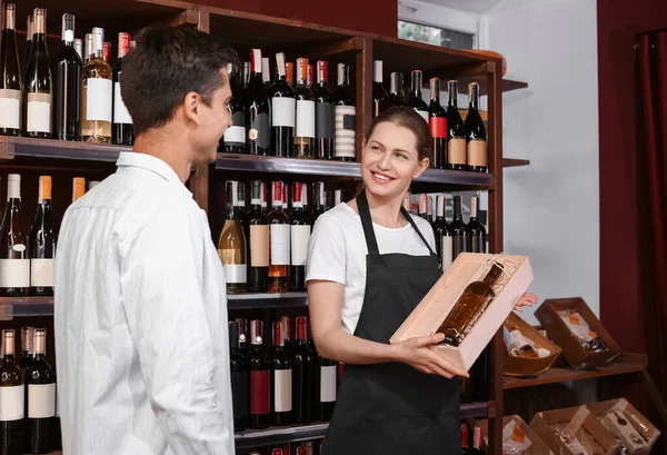 Vrouwelijke Verkoper Helpt Man Wijn Kiezen Winkel — Stockfoto