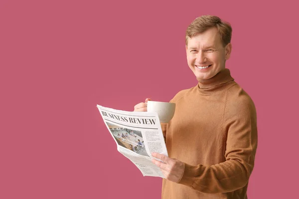 一个英俊的男人 有一杯茶和一份彩色背景的报纸 — 图库照片