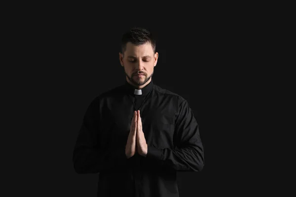 暗い背景にハンサムな祈りの司祭 — ストック写真