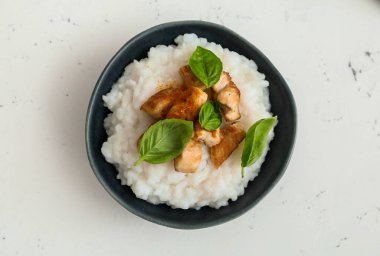 Kaynamış pirinç ve beyaz arka planda tavuk.