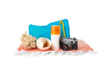 Beyaz arka planda güneş kremi ve fotoğraf makinesi olan çanta.