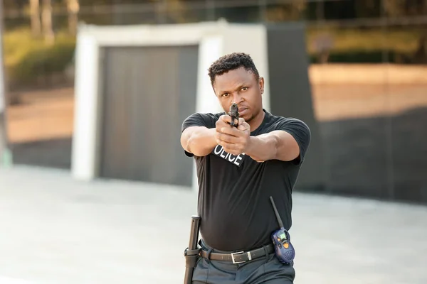 具有侵略性的非洲裔美国警官 在室外带枪 — 图库照片