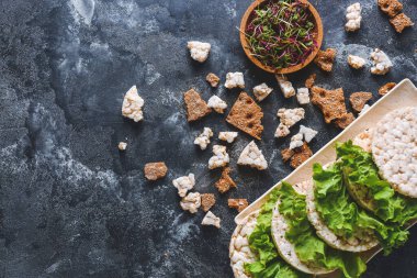 Koyu arkaplanda pirinç gevreği, salata ve lahanalı tabak.