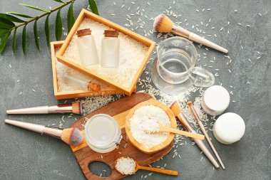 Sağlıklı pirinç suyu ve koyu arkaplanda kozmetik malzemeleri.