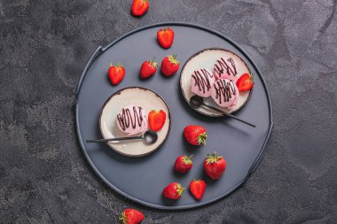 Koyu arkaplanda lezzetli çilekli dondurma tabakları