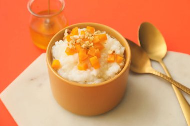 Arkaplanda haşlanmış pirinç ve balkabağı ile kase