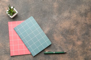 Koyu arkaplanda kalem bulunan defterler