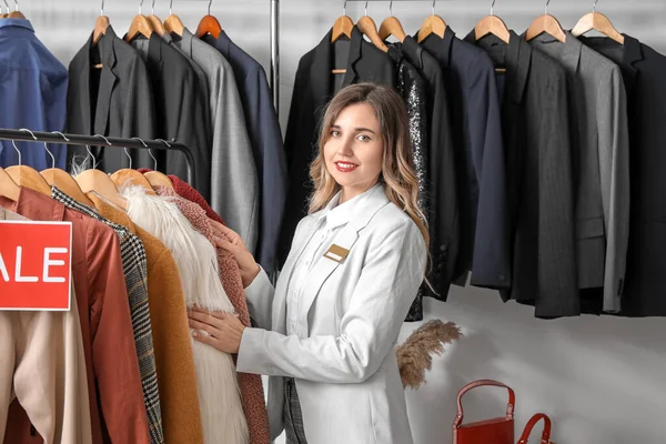 Female seller in modern clothes store