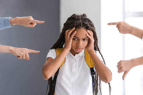 Pupils bullying African-American girl at school. Stop racism