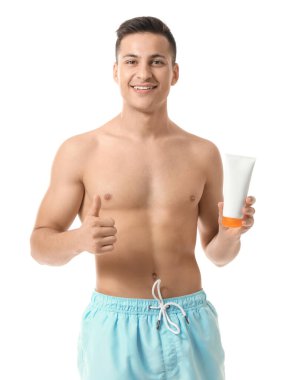 Beyaz arka planda güneş koruyucu kremi olan mutlu genç bir adam.