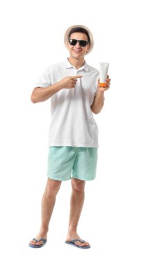 Beyaz arka planda güneş koruyucu kremi olan mutlu genç bir adam.