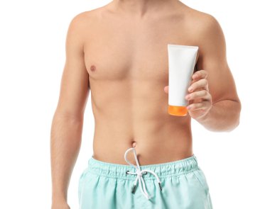 Beyaz arka planda güneş koruması kremi olan genç bir adam.