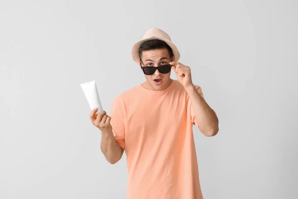 Surprised Young Man Sun Protection Cream Light Background — Stock Photo, Image