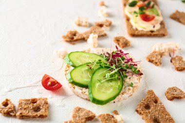 Beyaz arka planda salatalıklı ve lahanalı lezzetli gevrek ekmek.