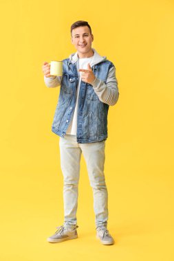 Arka planda çay fincanı olan yakışıklı genç adam.