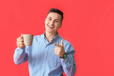 Arka planda çay fincanı olan yakışıklı genç adam.