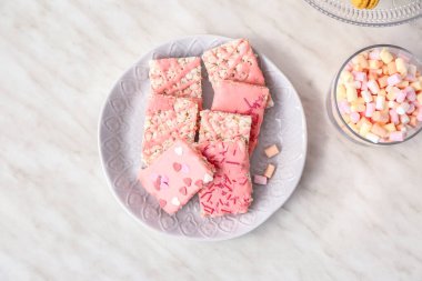 Beyaz arka planda gevrek pirinç çubukları ve marşmelovlu tabaklar.