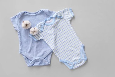 Gri arkaplanda pamuk bebek kıyafetleri