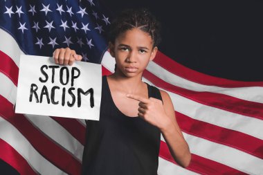 Amerikan bayrağına karşı afişi olan üzgün bir Afro-Amerikalı kız. Irkçılığı bırak