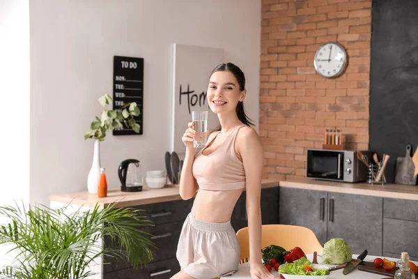 美しい若い女性は台所で水を飲む — ストック写真