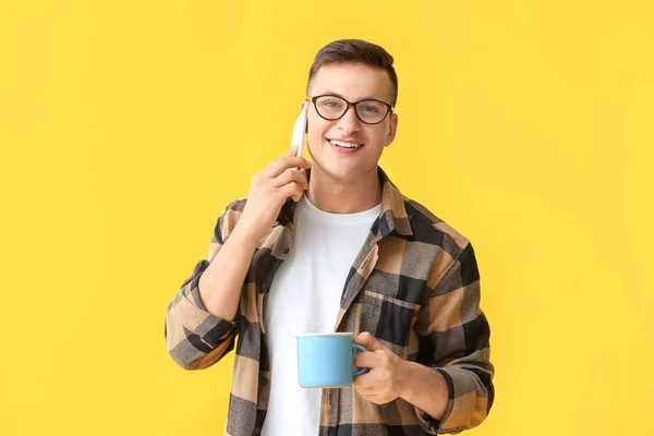 Bonito Jovem Com Xícara Chá Falando Por Telefone Fundo Cor — Fotografia de Stock