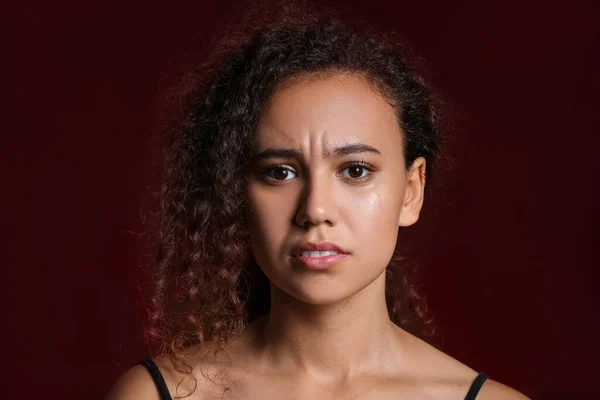 Sad African-American woman on dark background. Stop racism