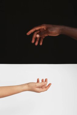 Siyah beyaz arka planda beyaz kadın ve Afro-Amerikan erkeğin elleri. Irkçılık kavramı