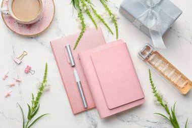 Not defterleri ve beyaz arka planda bir fincan kahve ile kompozisyon