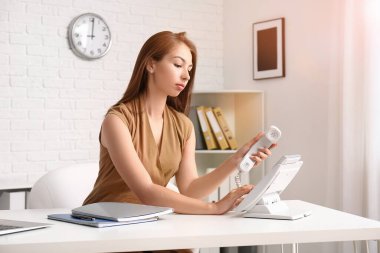 Ofiste çalışan genç ve güzel bir iş kadını.