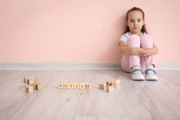 Маленькая Девочка Аутистическим Расстройством Кубиками Сидящими Возле Цветной Стены — стоковое фото