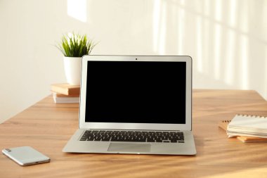 İş yerinde cep telefonu olan modern bir laptop.