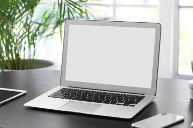 Çalışma odasındaki modern laptop ve cep telefonu