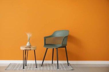 Renkli duvarın yanındaki sandalyeli masa.