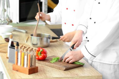 Asyalı aşçılar mutfakta birlikte yemek pişiriyor.