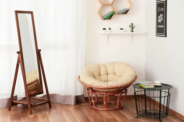 Big mirror and armchair in interior of room