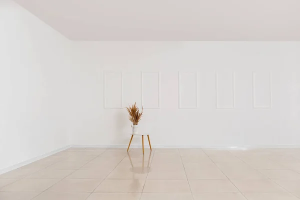 Table with floral decor in empty spacious room