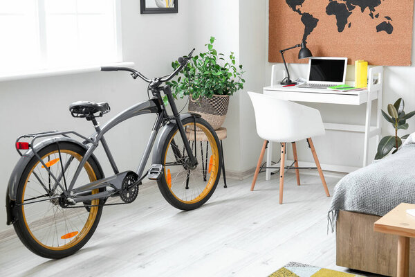 Стильный интерьер спальни с велосипедом и столом