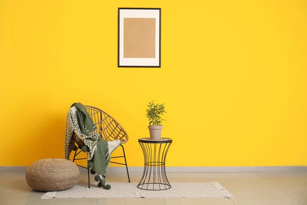 Tisch Mit Zimmerpflanze Korbstuhl Und Hocker Der Nähe Der Wand — Stockfoto